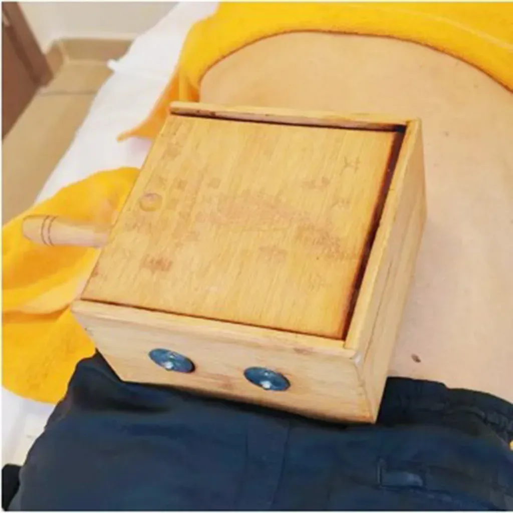 玉足養生館 — 艾灸溫熱調理，木製灸盒置於背部